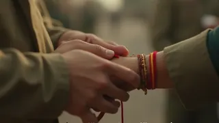 Schülerinnen binden Soldaten an der Kontrolllinie das traditionelle Armband